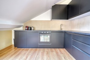 A modern kitchen with a built-in oven, a sink, and a countertop with a kettle and coffee maker. - 4G. 3-Bedroom Apartment for 6 People, Paris 15th Arrondissement, AC (Paris)