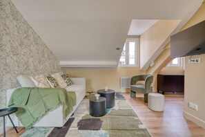 Uma sala de estar moderna com um sofá, uma mesa de centro e uma televisão.