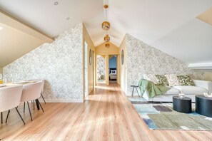 Um loft moderno com área de jantar, um sofá e escada que leva a um andar superior.