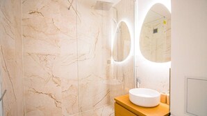 A bathroom with a marble wall, a round sink, and a mirror. - Studio for 2 People - Hotel de Ville - Marais - Paris 04 - Central (Paris)