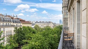 A balcony with a view of a cityscape, including buildings and trees. - A4.Premium-Arc de Triomphe-Champs-Élysées-3 Bedrooms (Paris)