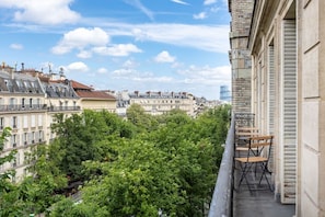 Uma varanda com vista para o horizonte urbano, incluindo edifícios e árvores.