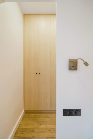 Ein Flur mit einem Holzschrank und einer Wandleuchte.
