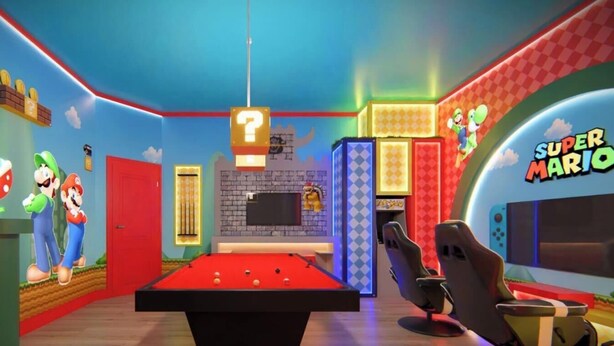 Een kamer met een pooltafel, decoraties in Mario-thema en een tv met het merk Super Mario.