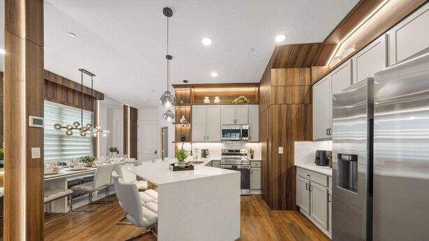A modern kitchen with a central island, stainless steel appliances, and wooden accents.