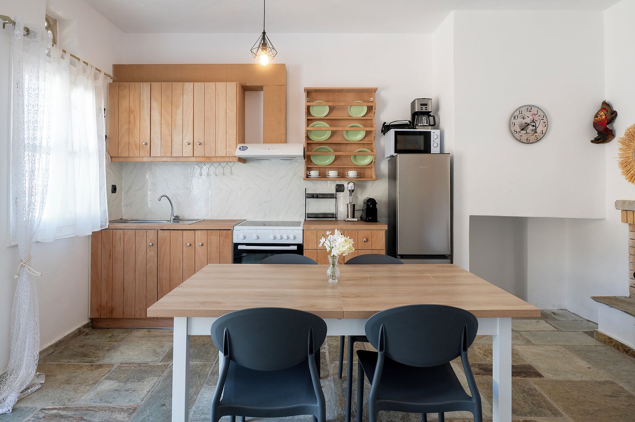Una cocina moderna con armarios de madera, horno empotrado, microondas y refrigerador.