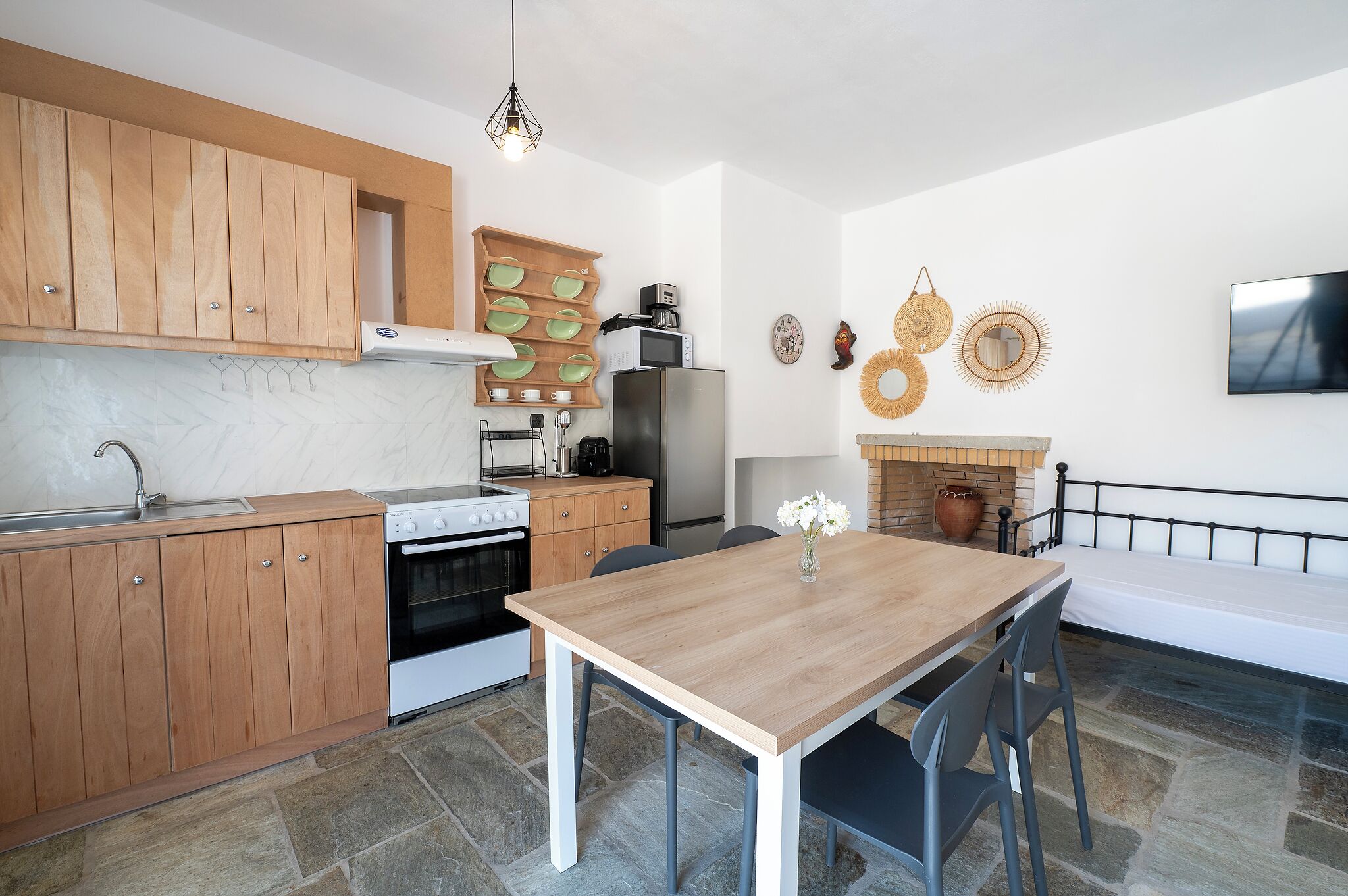 A modern kitchen with wooden cabinets, a stove, a refrigerator, and a dining table with chairs.