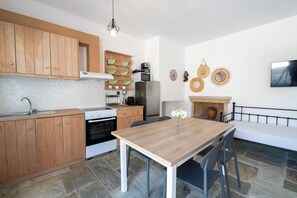 Una cocina moderna con armarios de madera, una estufa, un refrigerador y una mesa de comedor con sillas.