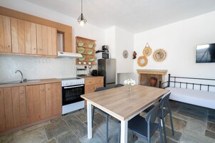 Una cocina moderna con armarios de madera, una estufa, un refrigerador y una mesa de comedor con sillas.