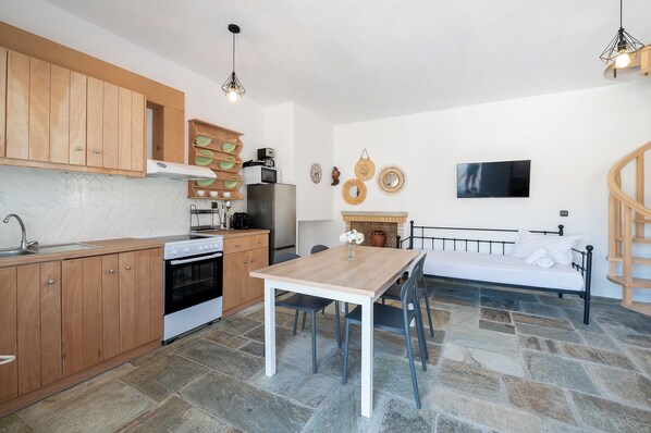 A compact kitchen with wooden cabinets, a dining table, and a built-in oven.