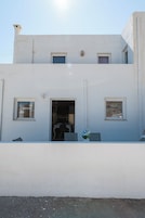 A two-story building with a flat facade, a central entrance, and two windows on the ground floor.