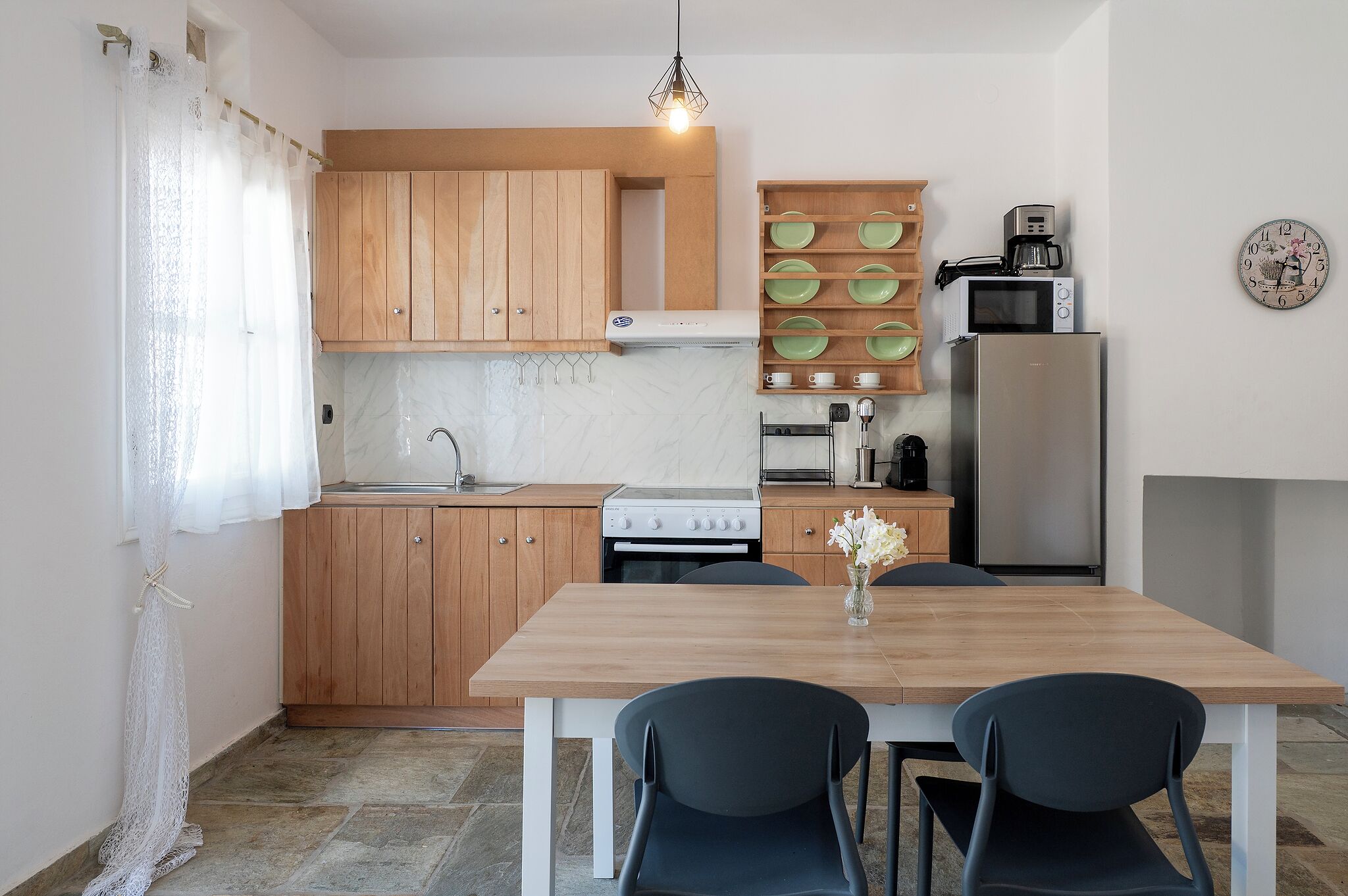 A modern kitchen with wooden cabinets, a built-in stove, a microwave, and a refrigerator.