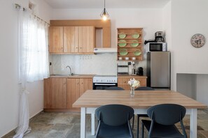 A modern kitchen with wooden cabinets, a built-in stove, a microwave, and a refrigerator.