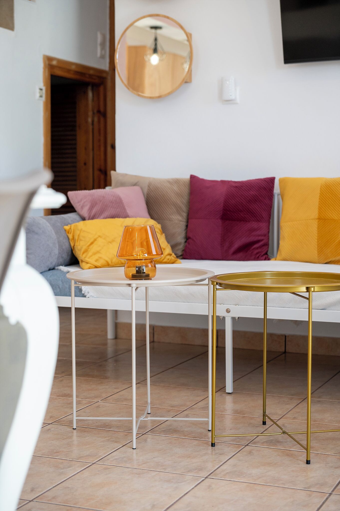 A modern living room with a sofa, a round table, and a lamp.