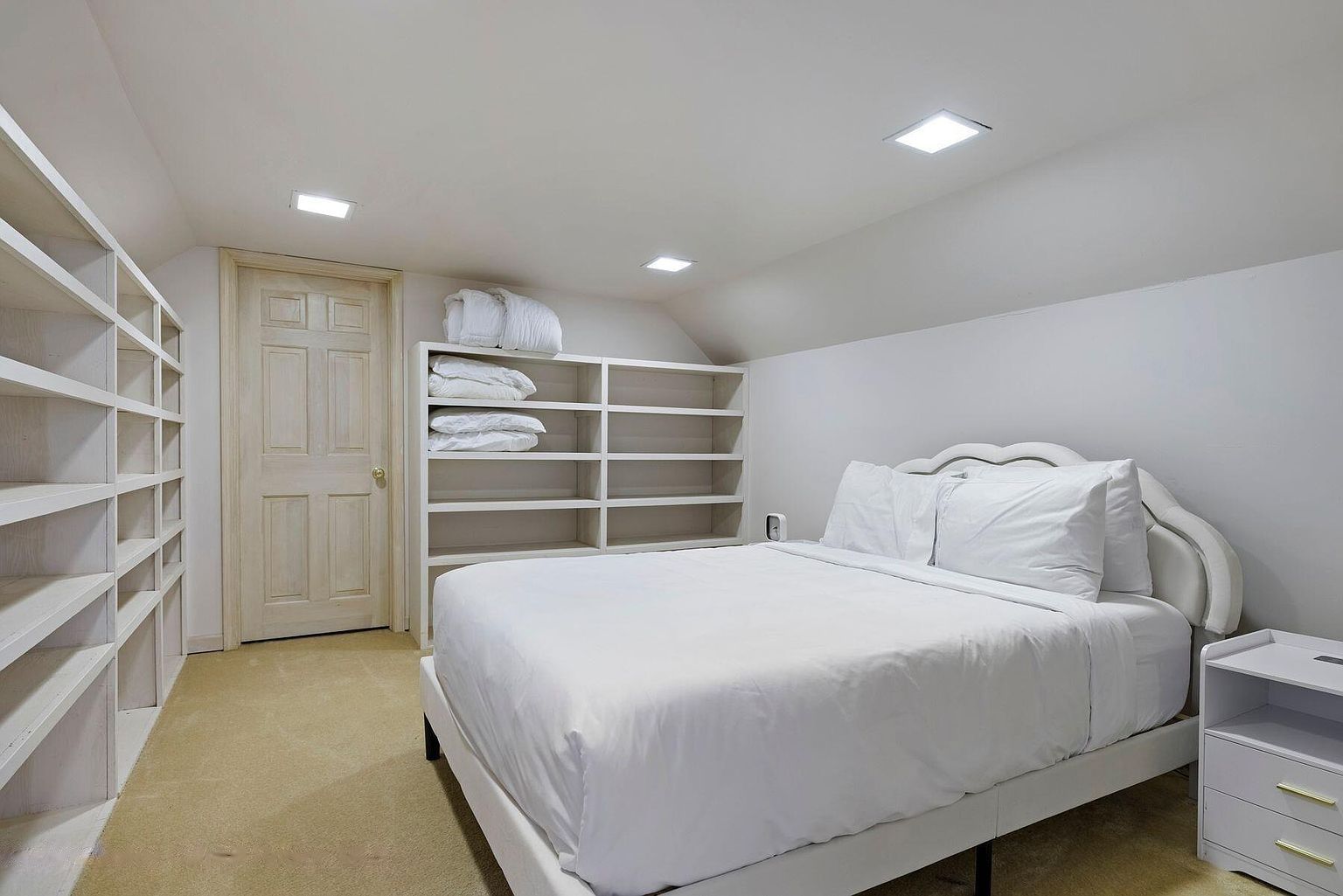 Une chambre à coucher avec un lit, une armoire et une table de chevet.