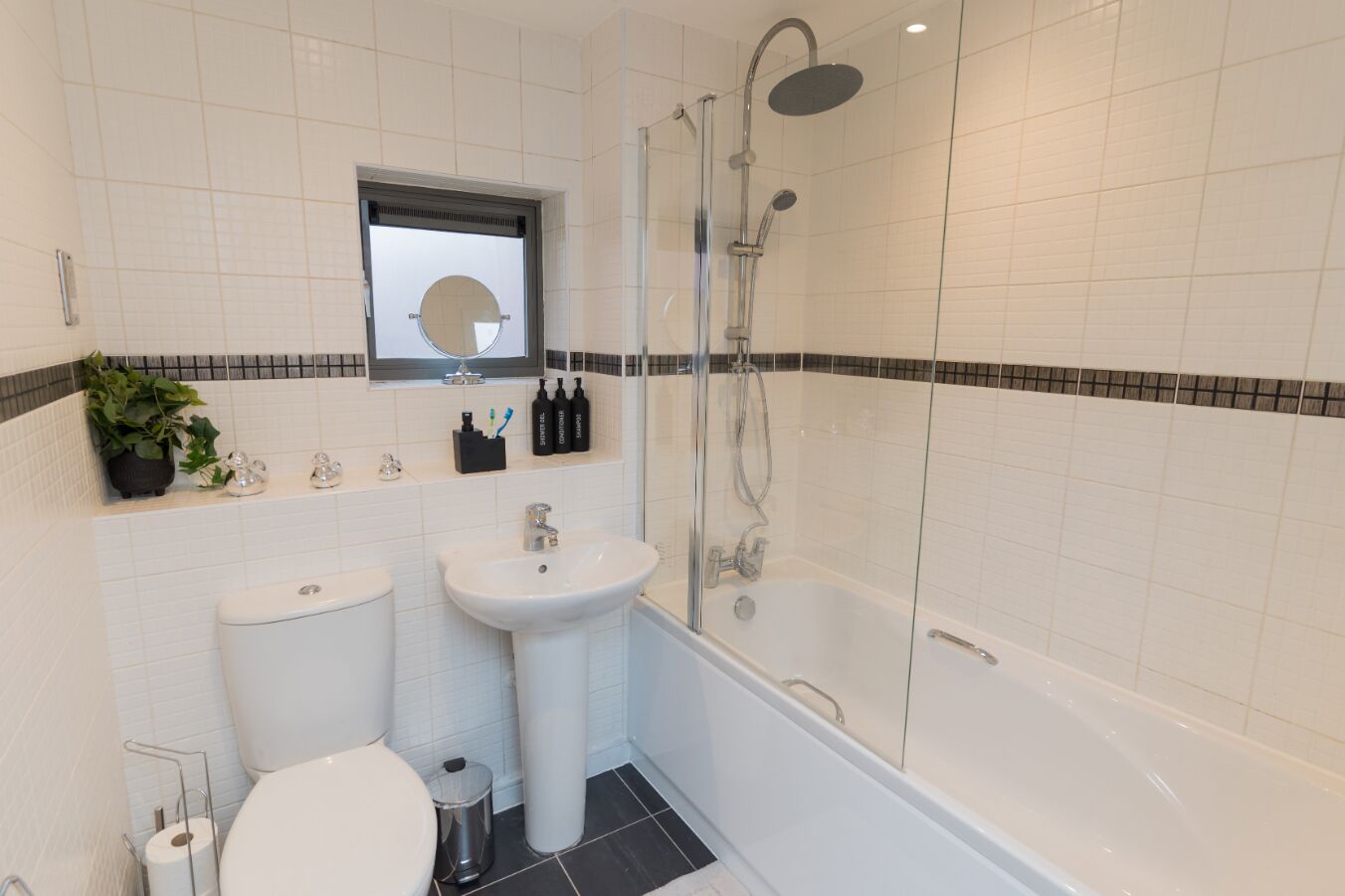 Ein modernes Badezimmer mit Toilette, Waschbecken und Dusche.