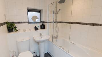 Ein modernes Badezimmer mit Toilette, Waschbecken und Dusche.