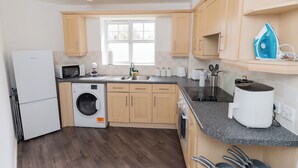 A modern kitchen with a built-in washer, a microwave, and a coffee machine. - Boutique 2-Bed Apartment in Wolverhampton Centre (Wolverhampton)