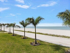 A beachside pathway lined with palm trees leading to a sandy beach. - Pointe South 401 | Resort Views + Pool (Fort Myers Beach)