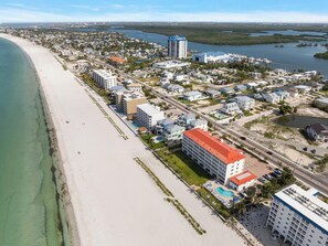 An aerial view of a coastal town with a beach, a marina, and various buildings including hotels. - Pointe South 401 | Resort Views + Pool (Fort Myers Beach)