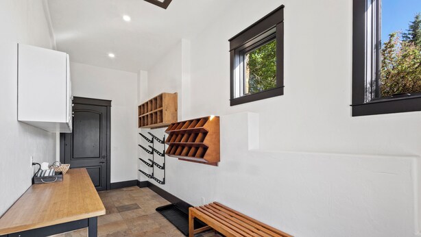 Una cucina moderna con forno integrato, una panca in legno e una cantina per vini.