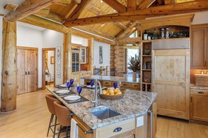 Eine geräumige Küche mit einer Granitarbeitsplatte, Holzschränken und einem integrierten Kühlschrank.
