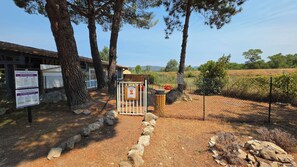 A fenced outdoor area with a wooden structure, a signboard, and a clear sky. - Lou Cigalou - Mobile Home - Sleeps 6 (La Roque-d'Anthéron)
