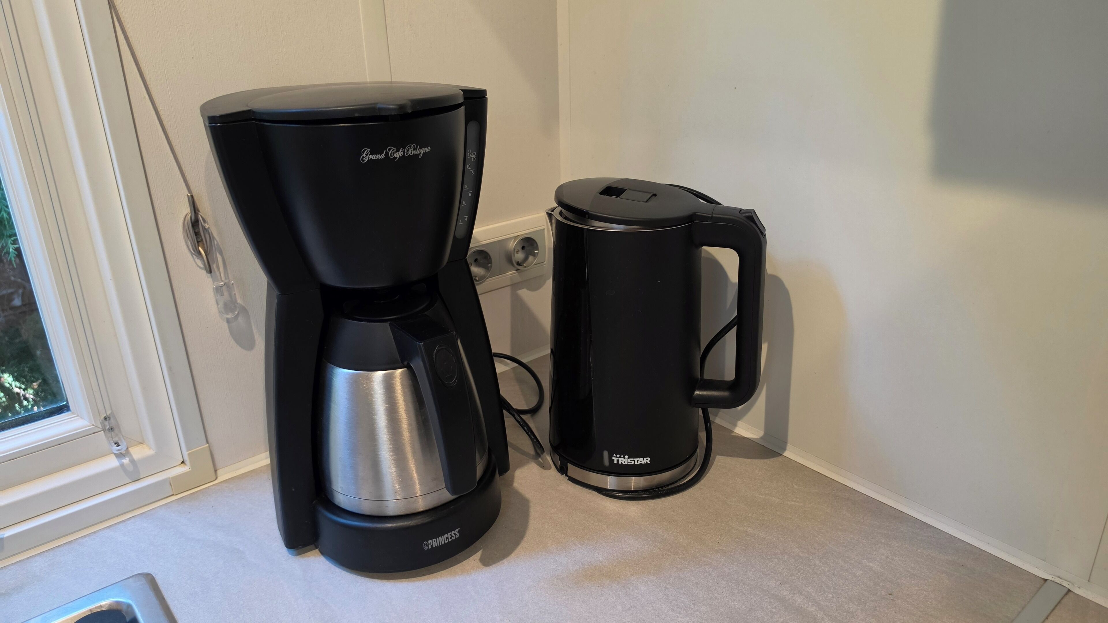 A coffee maker and a coffee pot on a kitchen counter.