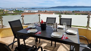 A table set for two with a view of a city and water in the background. - Villa 'Rocco-Salzwasserpool-Split' with Wi-Fi (Kaštel Gomilica)