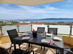 A table set for two with a view of a city and water in the background.