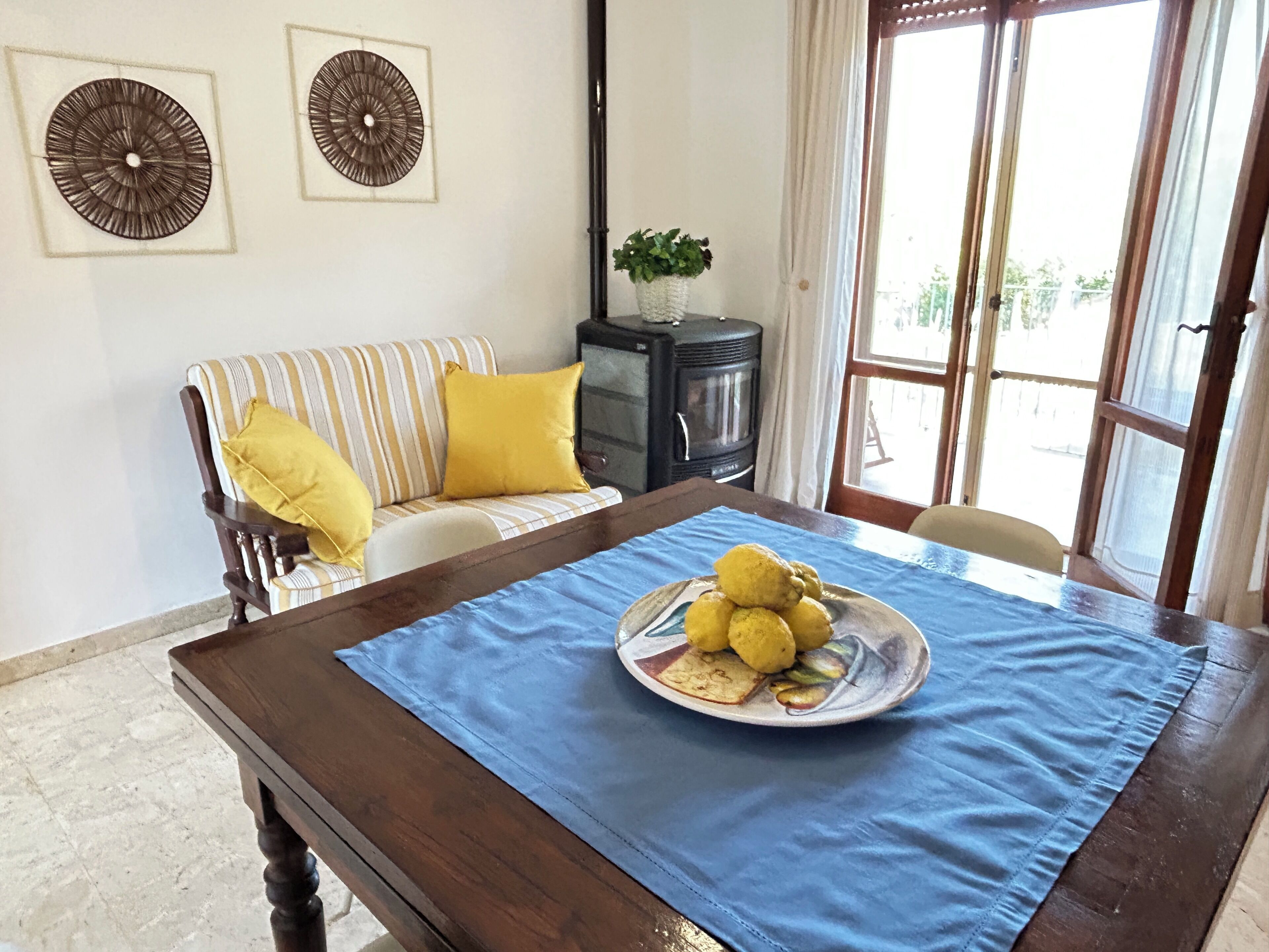 A dining area with a wooden table, a blue tablecloth, and a plate of food.