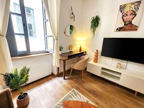 A modern living room with a desk, chair, TV, and a potted plant. - Downtown - 3 minutes from the arenas - Scandinavian decor (Nîmes)