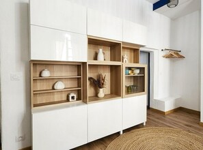 A white cabinet with multiple shelves, some containing decorative items. - City Center - 3 min from the Arènes - Scandinavian Decor (Nîmes)