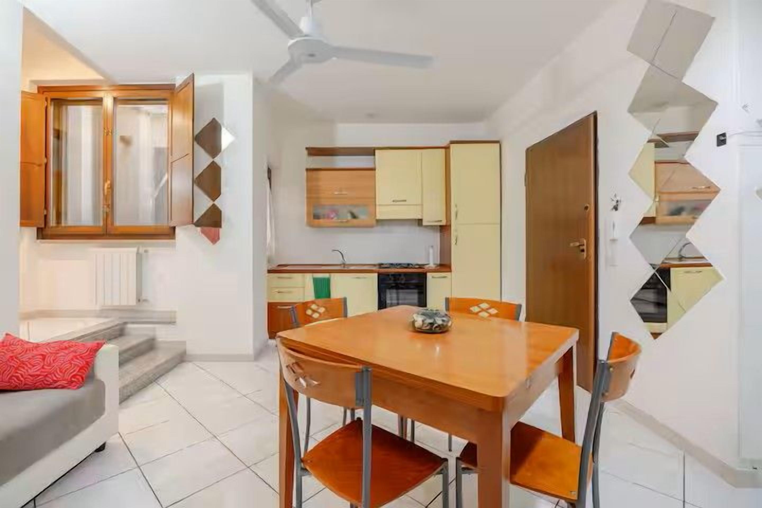 Un espacio habitable pequeño con comedor, kitchenette y sofá.