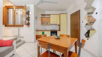 Un espacio habitable pequeño con comedor, kitchenette y sofá.