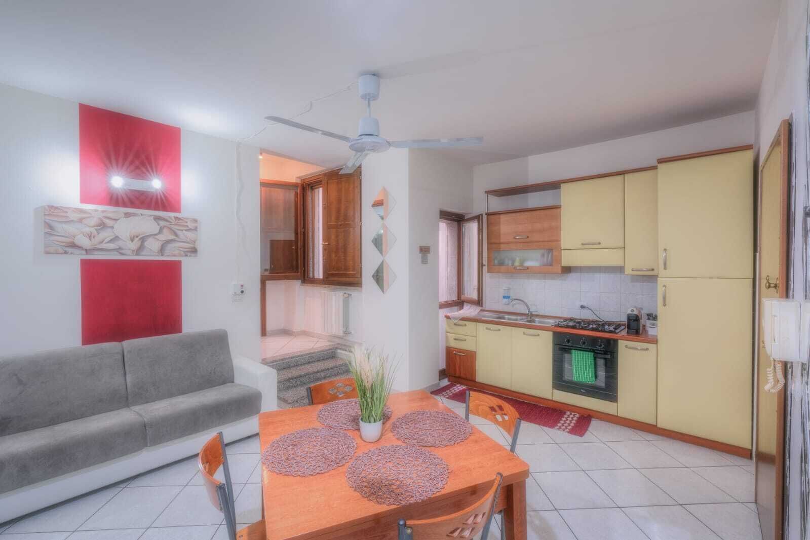 Un espacio habitable compacto con comedor, kitchenette y sofá.