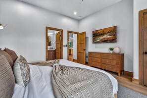 Ein Schlafzimmer mit einem Bett, einem Holzschrank und einem Bild an der Wand.