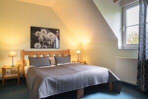 A bedroom with a bed, two bedside tables, a nightstand, a window with curtains, and a wall-mounted picture. - Holiday Home 'Ferienhof Homann Sauerland - LH 7' with Shared Terrace and Wi-Fi (Brilon)