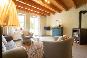 A living room with a fireplace, sofas, a coffee table, and a TV. - Holiday Home 'Ferienhof Homann Sauerland - LH 7' with Shared Terrace and Wi-Fi (Brilon)