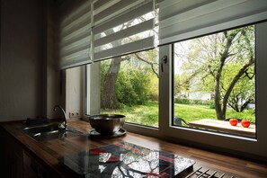 Eine Küche mit einem großen Fenster, einer Spüle und einer Schüssel auf der Arbeitsfläche.