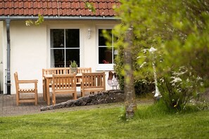 A house with a tiled roof, a wooden bench, a chair, and a window. - Apartment 'Ferienhof Homann Sauerland - BH 5' (Brilon)