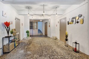 A hallway with a stone floor, a staircase, and a wall with abstract art. - Room '1er Étage - Écrin de Saphir' with shared terrace and Wi-Fi (Millas)