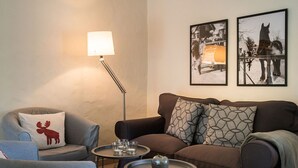 A living room with a sofa, armchair, and a floor lamp. There are two framed pictures on the wall. - Apartment 'Ferienhof Homann Sauerland - LH 6 Balcony and Wi-Fi' (Brilon)