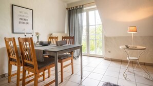 A dining area with a table, chairs, a vase with flowers, a framed sign, and a lamp. - Apartment 'Ferienhof Homann Sauerland - LH 6 Balcony and Wi-Fi' (Brilon)