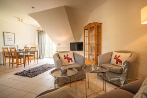Ein Wohnzimmer mit Essbereich, Fernseher und Kamin.