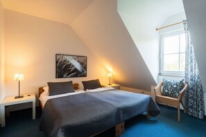 A bedroom with a bed, two bedside tables, a lamp, a chair, and a window with curtains. - Holiday Home 'Ferienhof Homann Sauerland - LH 2' with Shared Terrace and Wi-Fi (Brilon)