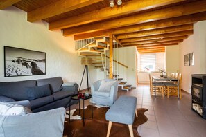 A living room with a sofa, a coffee table, a fireplace, and a staircase leading to another room. - Holiday Home 'Ferienhof Homann Sauerland - LH 2' with Shared Terrace and Wi-Fi (Brilon)