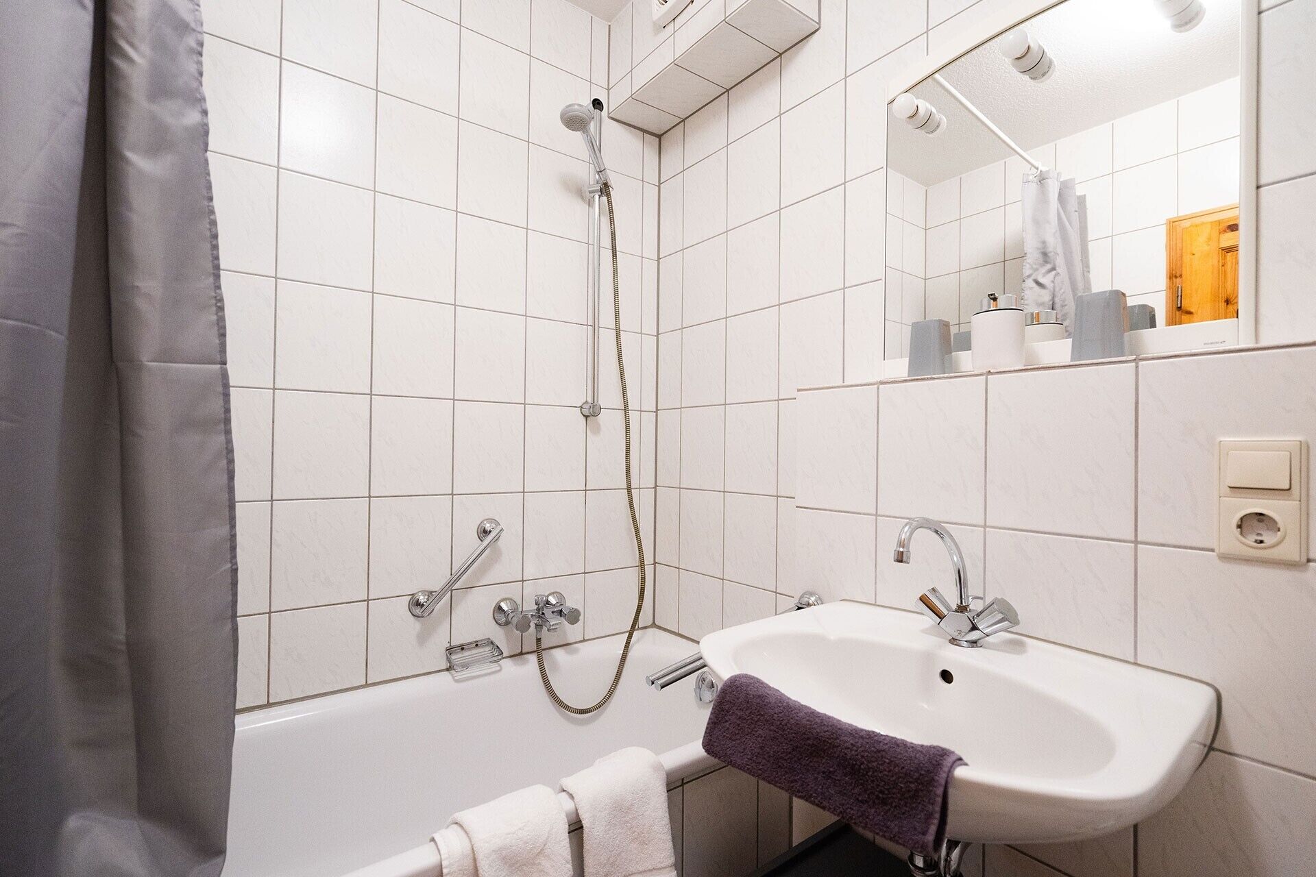Een badkamer met een bad, een wastafel en een douche.