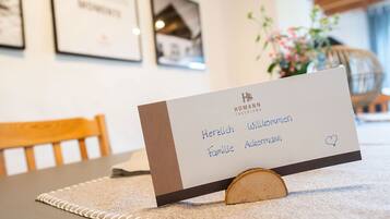 A hotel reception desk with a sign that reads 'HOMANN SAUERLAND' and 'Herzlich Willkommen Familie Ackermann' with a heart symbol.