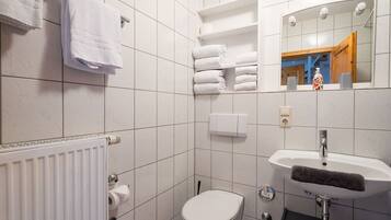 Ein Badezimmer mit Toilette, Waschbecken, Handtuchhalter und Spiegel.